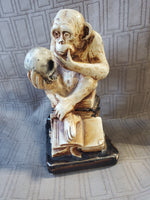 Thinking Monkey Sitting on Stack of Books Holding Skull Statue