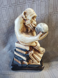 Thinking Monkey Sitting on Stack of Books Holding Skull Statue