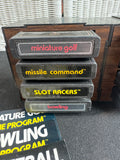 Lot of 8 Assorted Atari 2600 & 7800 Games with Manuals in 8-Cartridge Musicmate Modular Storage Rack (B)